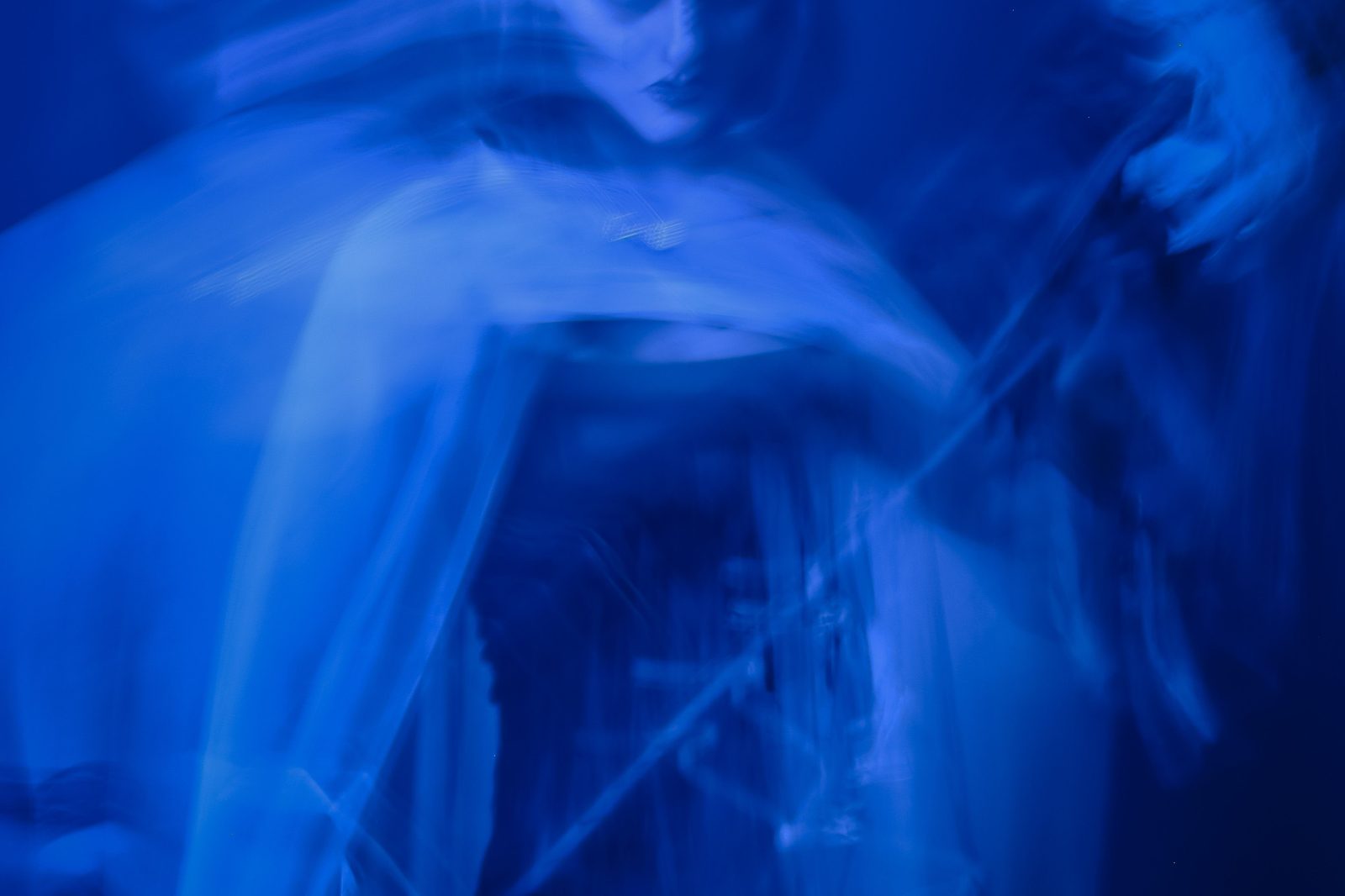 A blue-toned, long-exposure blur of a figure caught in motion